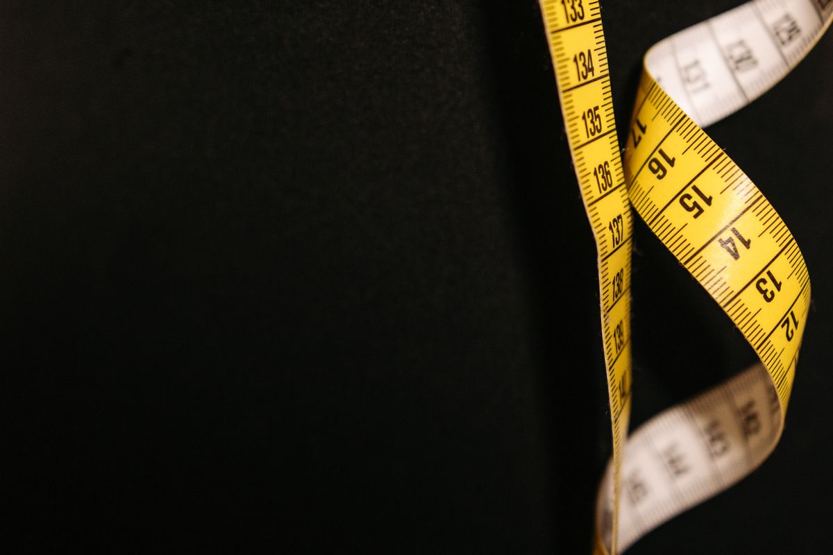 Measuring tape across the chest of a shirt laid flat on a table