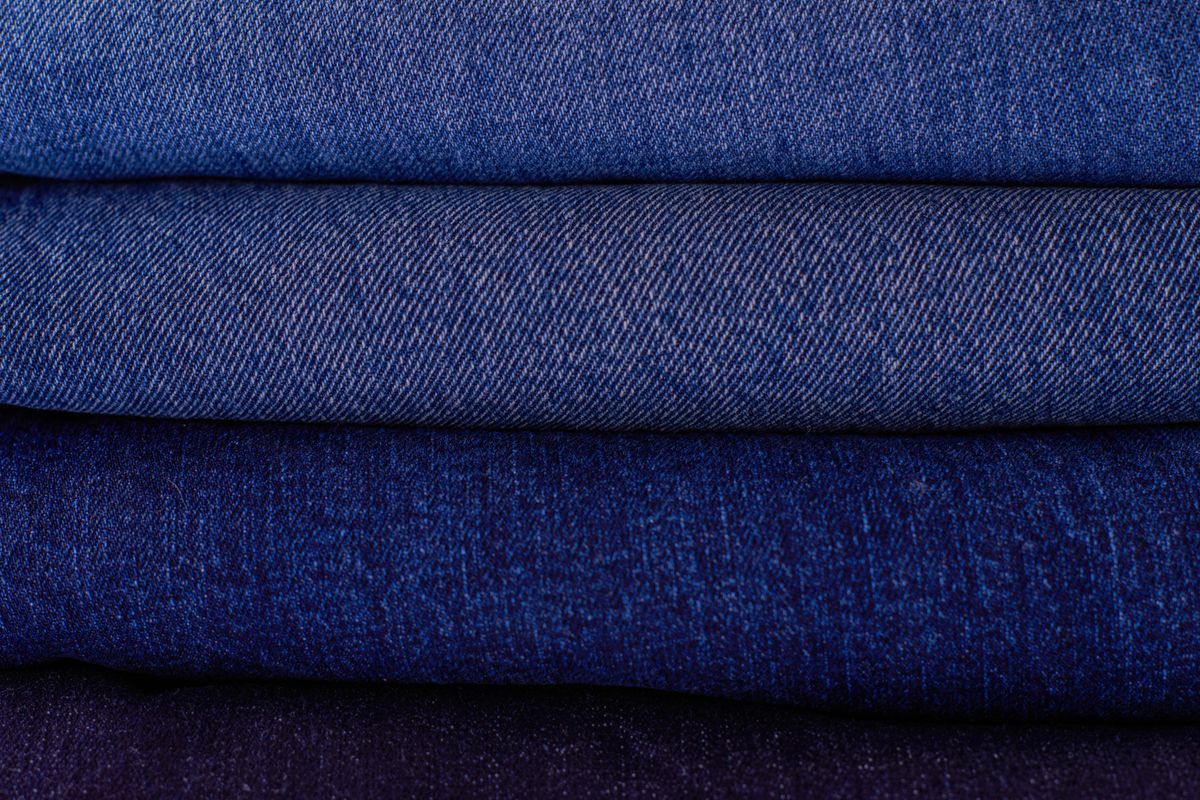 Raw indigo denim fabric edge showing white selvedge line