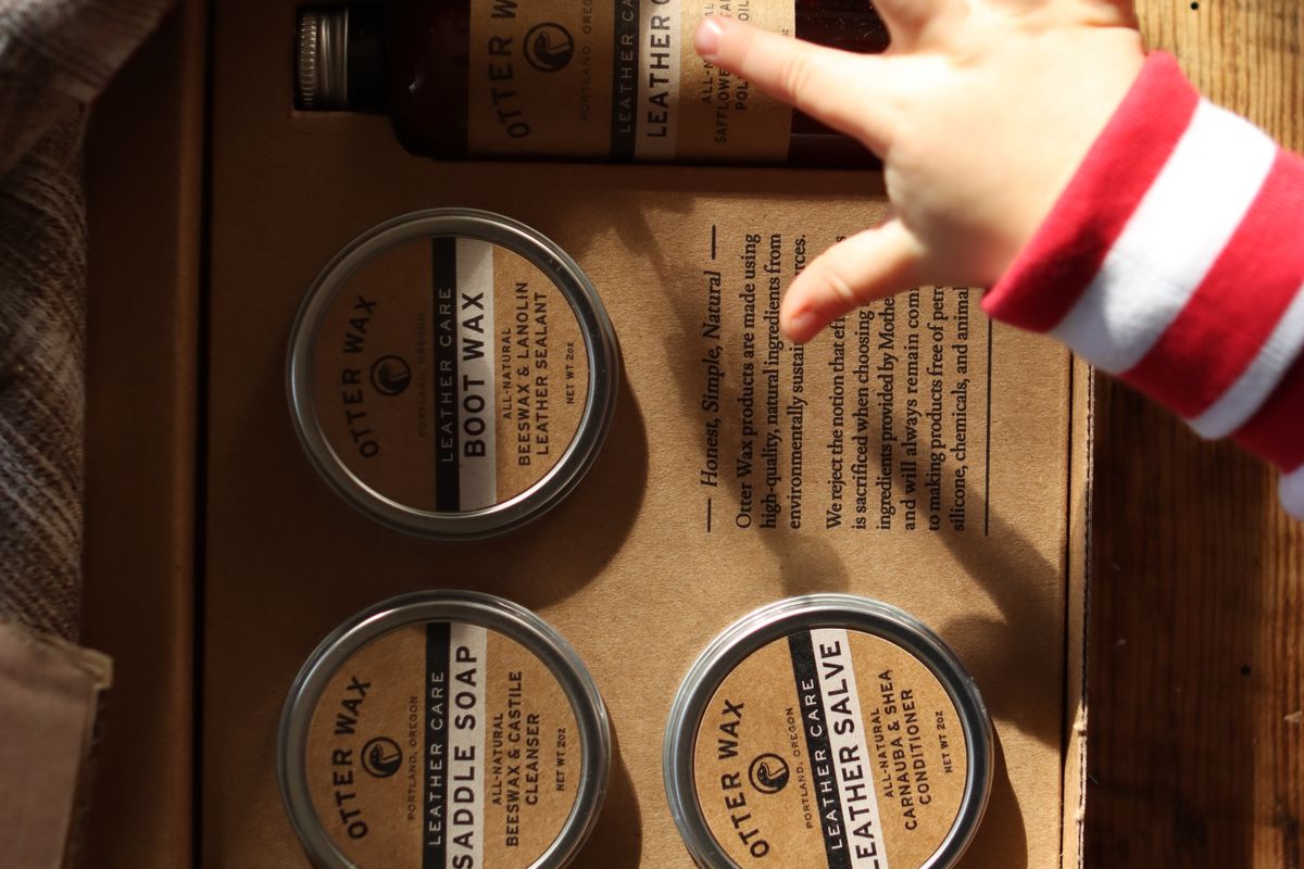 A waxed cotton jacket being treated with a tin of wax dressing