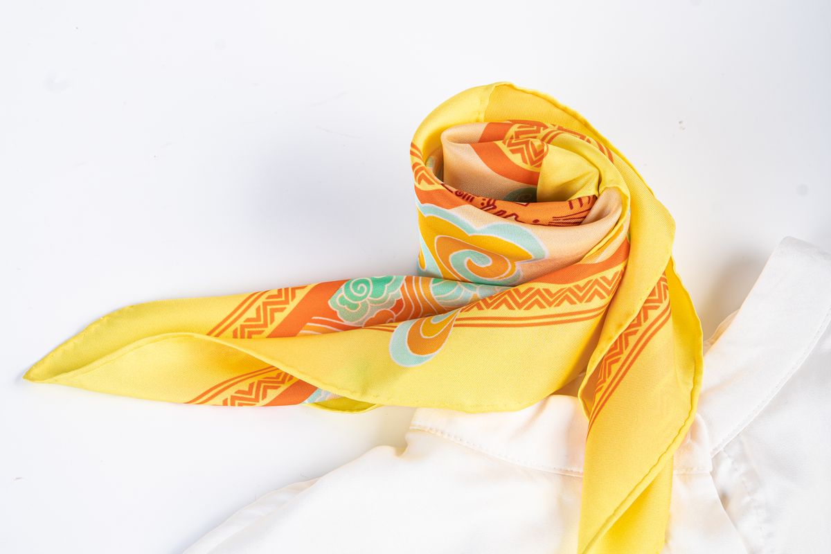 A folded silk scarf showing its twill texture in soft light