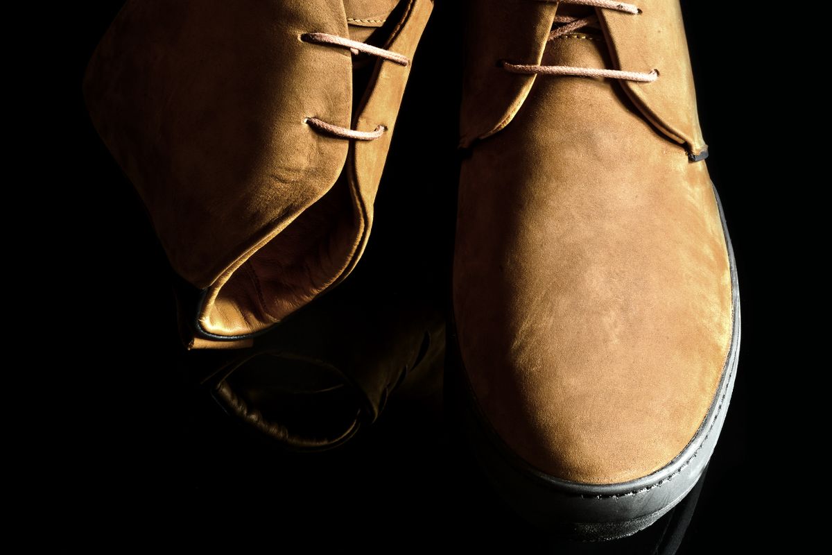 A suede shoe being brushed with a crepe brush beside a rubber eraser